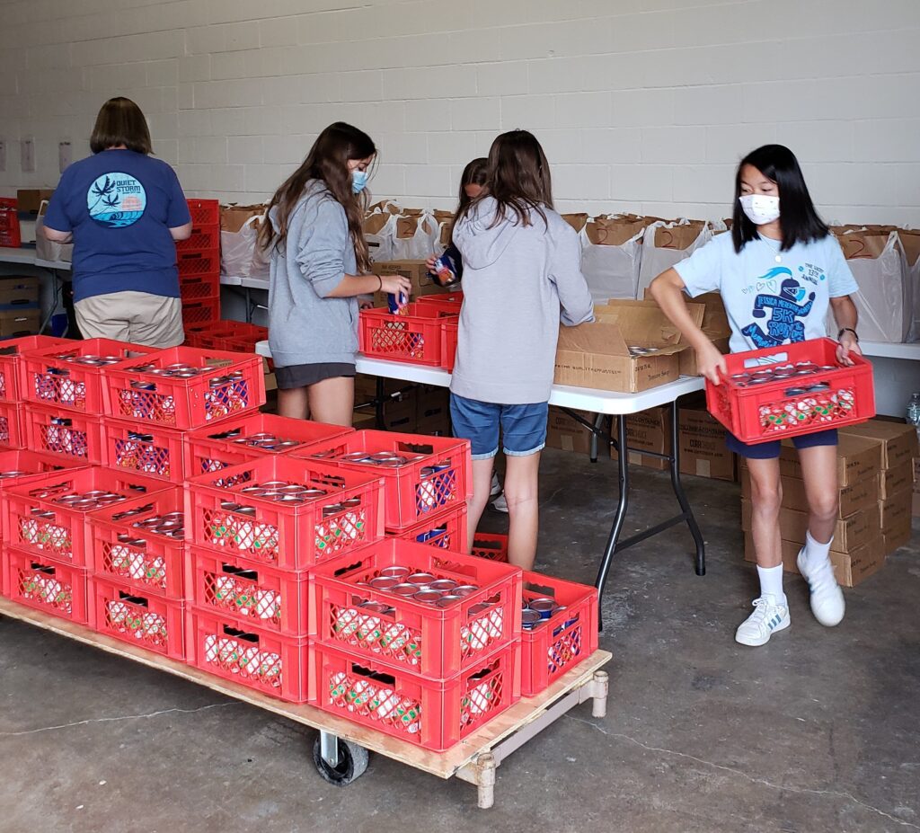 Four members of Youth Work Camp sorting canned goods